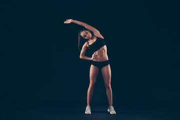 Full length body size view of her she nice attractive adorable sportive confident flexible strong muscular lady fitness model doing exercise inclining aside sculpt isolated over black background