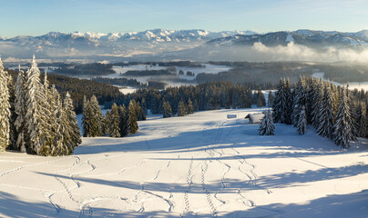 Amazing Panorama View from Snow Mountain with Forest to snowy and foggy Mountain Range. Mountain Hut Klings Huette on Hauchenberg near Diepolz in Allgau, Bavaria, Germany.