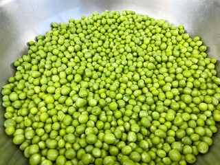 Grains of raw green peas in a metal bowl. Concept of healthy food, agriculture.