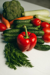Fresh vegetables on a white background. Red pepper, broccoli, zucchini, tomatoes, cucumbers, carrots, dill. Healthy organic food for vegetarians. Ingredients for summer salad.