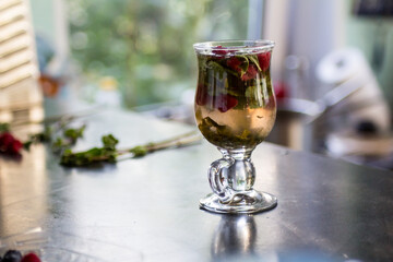 refreshing berry cocktail with mint, lemon, lime and raspberries in a beautiful glass with a green straw