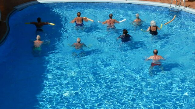 People doing acquagym in swimming pool in a resort, tourism after coronavirus pandemic