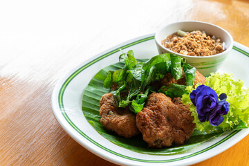 Fried Fish-Paste Balls with fresh vegetable on wooden table. Thai Traditional Foods.