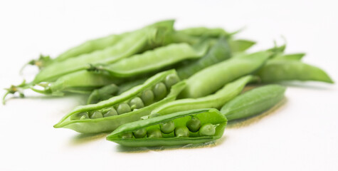 Food background. Green pods of young peas on a light wooden table. Close-up.