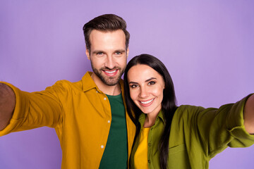 Fototapeta premium Closeup photo of pretty overjoyed lady handsome guy couple spend quarantine together making selfies bloggers wear bright shirts isolated purple color background