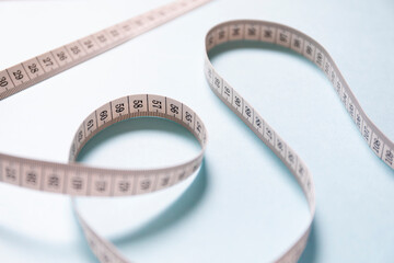 ランダムに置かれた巻尺　薄い水色の背景