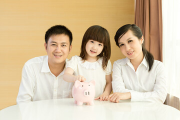 Parents teaching daughter to save money at home