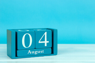 wooden calendar with the date of 
August 4 on a blue wooden background