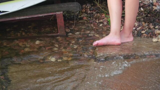 A girl with bare feet tries the surf