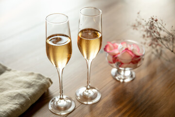 Glasses of sparkling champagne with sweets, close up. Warm colored. Celebration event, holidays, drinks concept. Companion for best family or friend's memories. Anniversary, wedding day or Christmas