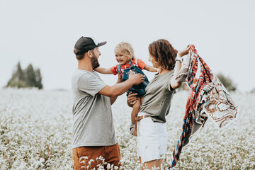 Outdoor atmospheric family portrait of a young beautiful woman, a man and from a daughter on a...