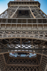 Architectural details of Eiffel tower. Antique metal base construction inside Eiffel tower in Paris France. Ornate rusted metal patterns of tower landmark