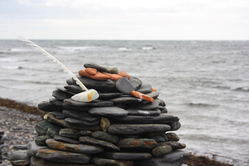 Pile of stones and a feather at a beach