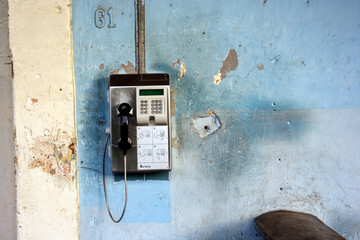 Old payphone on a blue wall