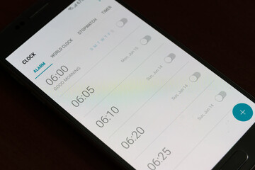 Smartphone screen with alarms turned off for every day close-up, background.
