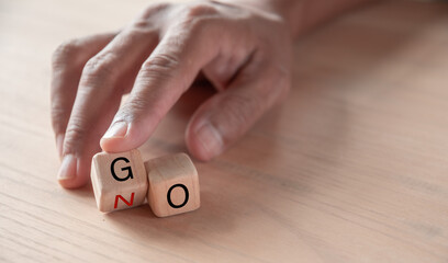 hand holding dice with text for illustration of "Go and No" words