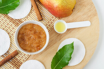 Pear puree, cinnamon sticks and cotton pads. Ingredients for preparing homemade mask or face scrub. Natural beauty treatment recipe, zero waste concept. Top view, copy space