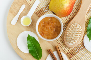 Pear puree, cinnamon sticks, wooden hair brush, olive oil, cotton pads. Ingredients for preparing homemade mask or face scrub. Natural beauty treatment recipe, zero waste concept. Top view, copy space