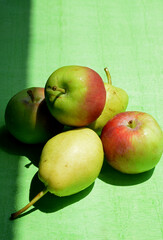 apples and pears on green background