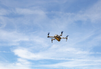 Fototapeta na wymiar Quadcopter drone with digital camera in flight with blue sky background..