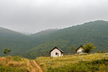 Fototapeta na wymiar A gloomy rainy landscape , with heavy clouds hiding the tops of the hills