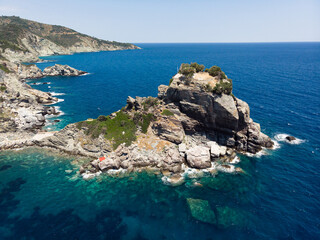 The church of Agios Ioannis on the Mamma Mia Cliff on the island of Skopelos, shaken by the blue Mediterranean sea.