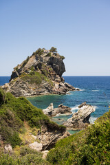 View from the coast to the church of Agios Ioannis on the Mamma Mia Cliff on the island of Skopelos, surrounded by the blue Mediterranean sea.