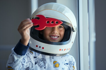 Child playing with astronaut helmet and toy rocket © Rido