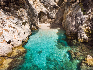 Fototapeta na wymiar Clear turquoise sea water in the Amarandos Cove on the island of Skopelos is a reminder of a refreshing holiday in the Mediterranean summer.