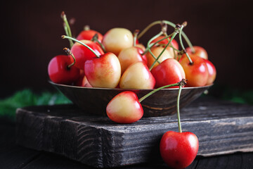 Fresh cherry in a Cup on a dark rustic wooden table. Background with space for copying. Selective focus.