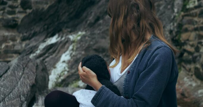 Young mother holding her baby outdoors in nature