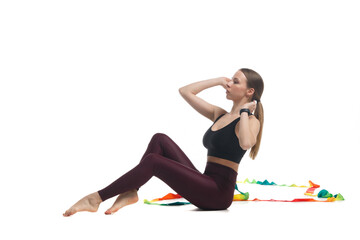 Young slim girl gymnast in sportswear is training with a multi-colored ribbon isolated on white background.