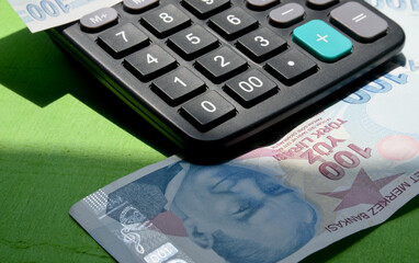 calculator and one hundred Turkish lira banknote