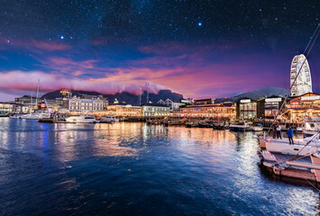 Fototapeta premium Illuminated Cape Town waterfront at night with stars in the sky
