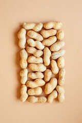 The texture with the walnuts on beige background. Peanuts in shells