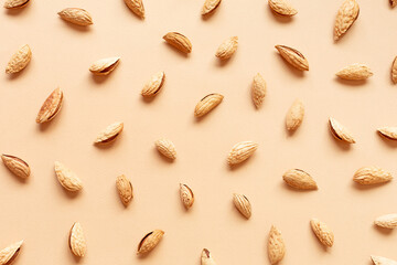 The texture with the walnuts on beige background. Almonds in shell.