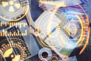 Tech theme hologram over woman's hands taking notes background. Concept of hightech. Double exposure