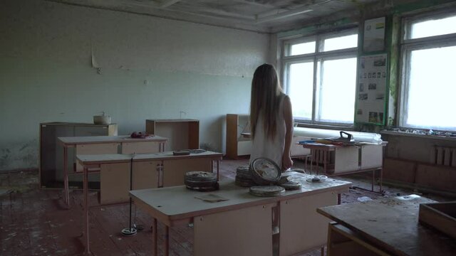 The camera moves down the hallway at the school - a girl in a white dress with long hair on her face. The interior of an abandoned house, post-apocalyptic ruins.
