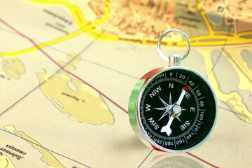 Classic round compass on old paper map as symbol of tourism with compass, travel with compass and outdoor activities with compass