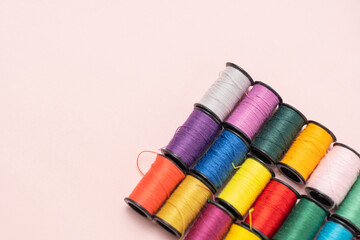 ピンクの背景のカラフルな縫い糸