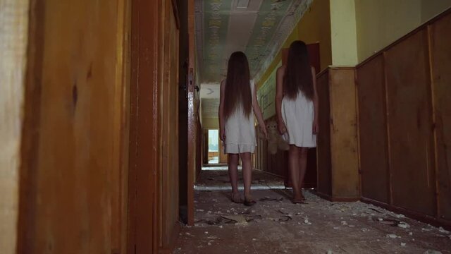 Two girls walk down the hall of the school, holding hands, facial hair. Mother and daughter or two sisters. Horror.Abandoned house. Mysticism.