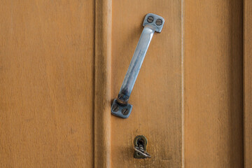 Wooden old brown wardrobe with metal handle