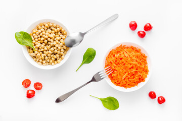 Vegetarian meal. Chickpeas and carrot in bowls on white table top view