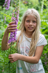 Mädchen beim Erforschen, Betrachten eines hoch giftigen  Roten Fingerhutes (Digitalis purpurea)...