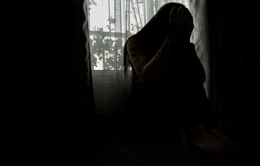 Sad young woman sitting on the bed in the bedroom, People with depression concept.	