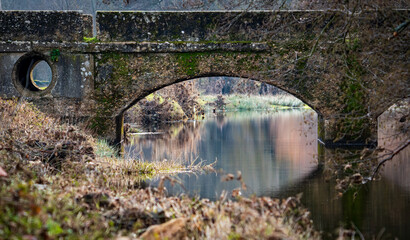 Antique bridge over river at winter time