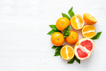 Oranges and grapefruits with leaves on table top view copy space