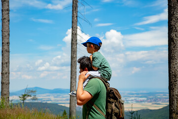 father and son are engaged in Hiking in the mountains, a view of the valley