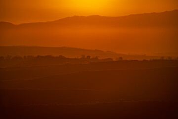 Hills profile compressed shot at sunset with orange colors