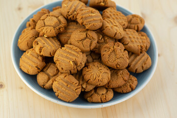 Very tasty peanut butter biscuits on bamboo light brown wooden board, golden baked healthy